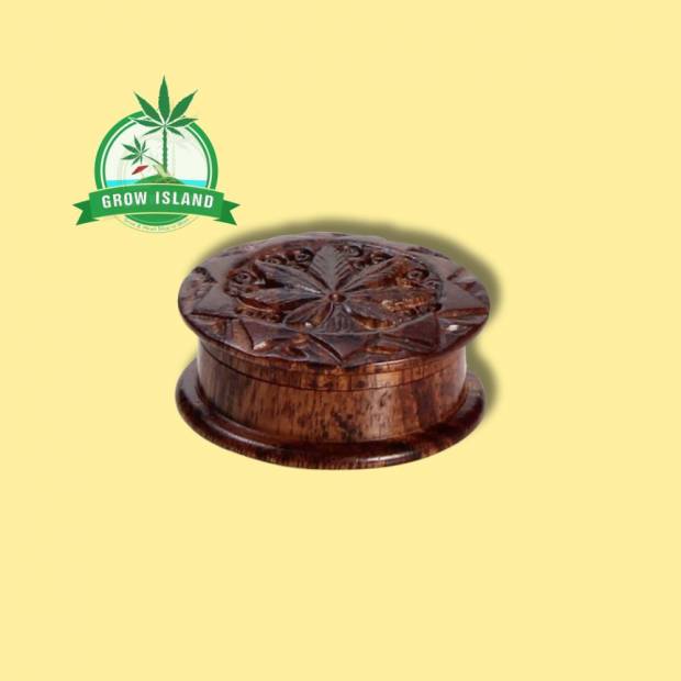 wooden Rosenholz-Grinder with creaved cannabis leafs on it and yellow background, and green grow island logo in the left upper corner
