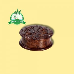 wooden Rosenholz-Grinder with creaved cannabis leafs on it and yellow background, and green grow island logo in the left upper corner